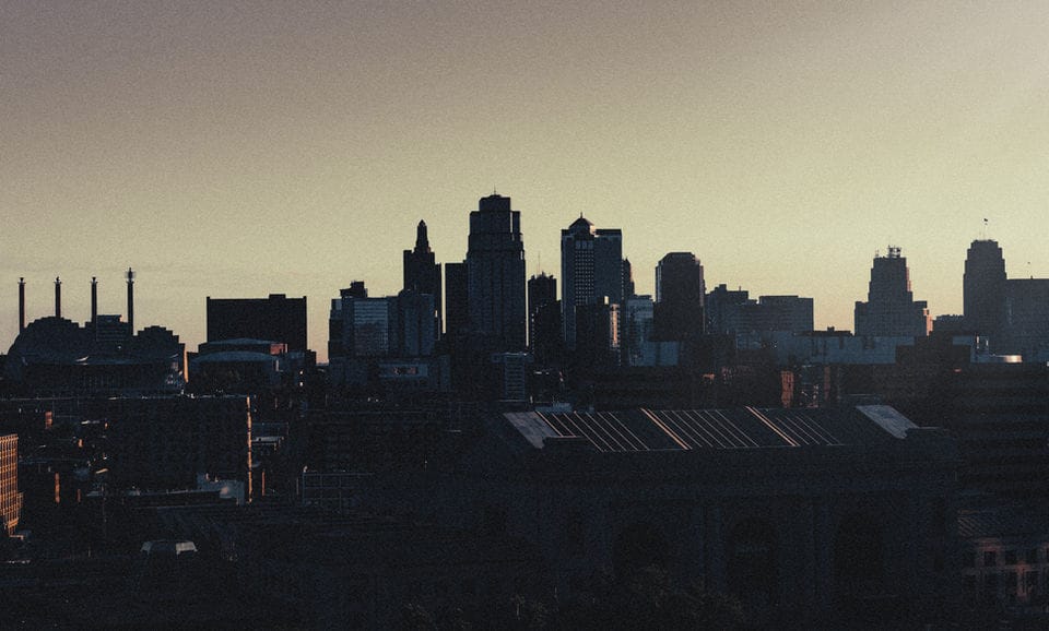 Kansas City skyline in silhouette against a hazy evening sky